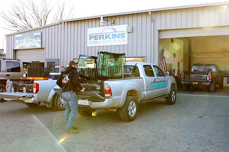 Auto glass repair technician with work truck