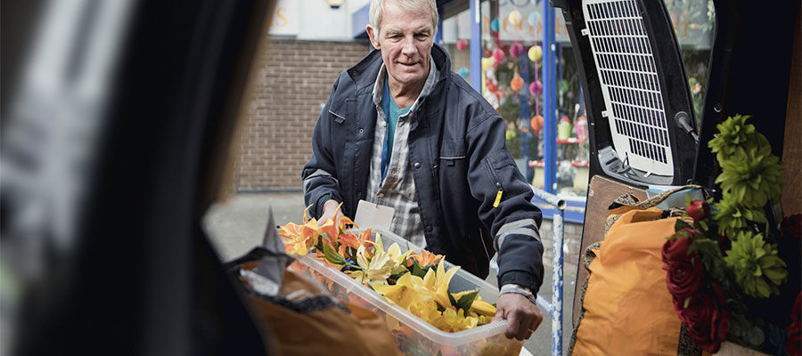 Florist loads arrangements into a van