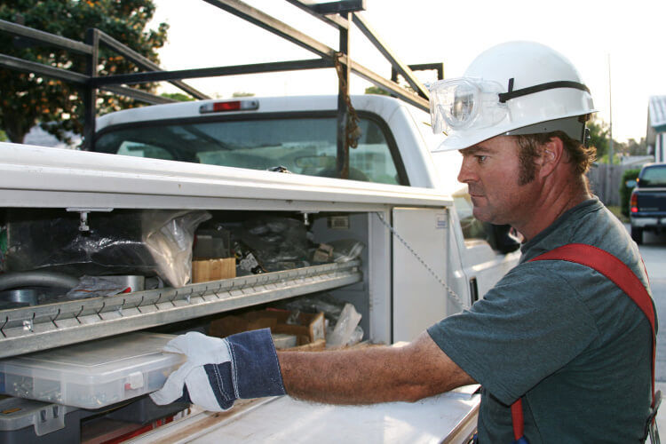 Electrician storing equipment on his work truck
