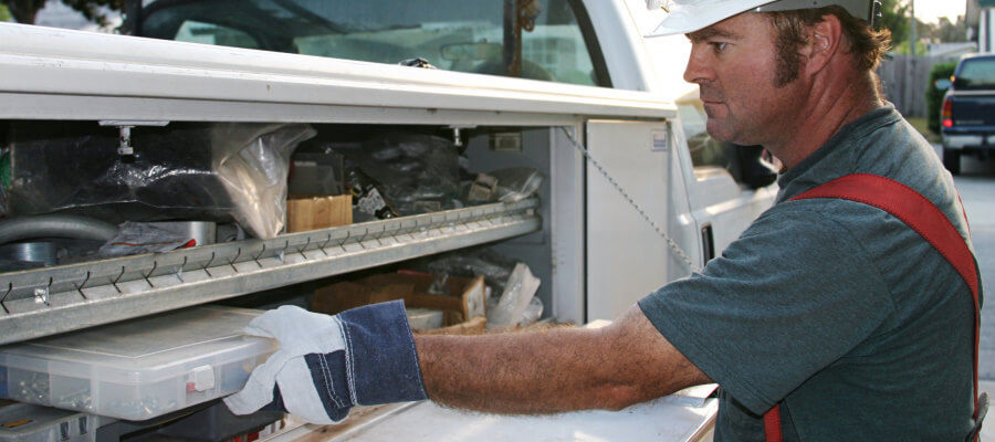 Electrician storing equipment on his work truck