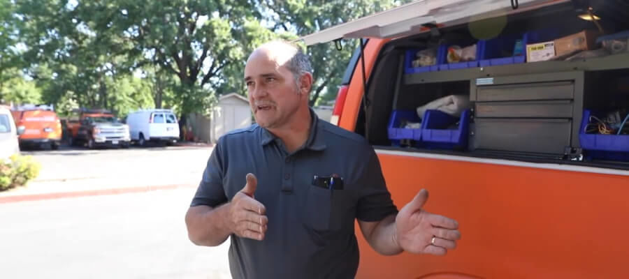 Electrician in front a van with bins for organizing parts