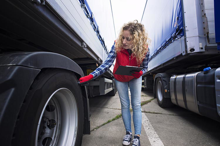 woman checking work truck tires home page image